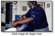 David Crawford giving a chair massage to an employee in an employer-sponsored massage program.